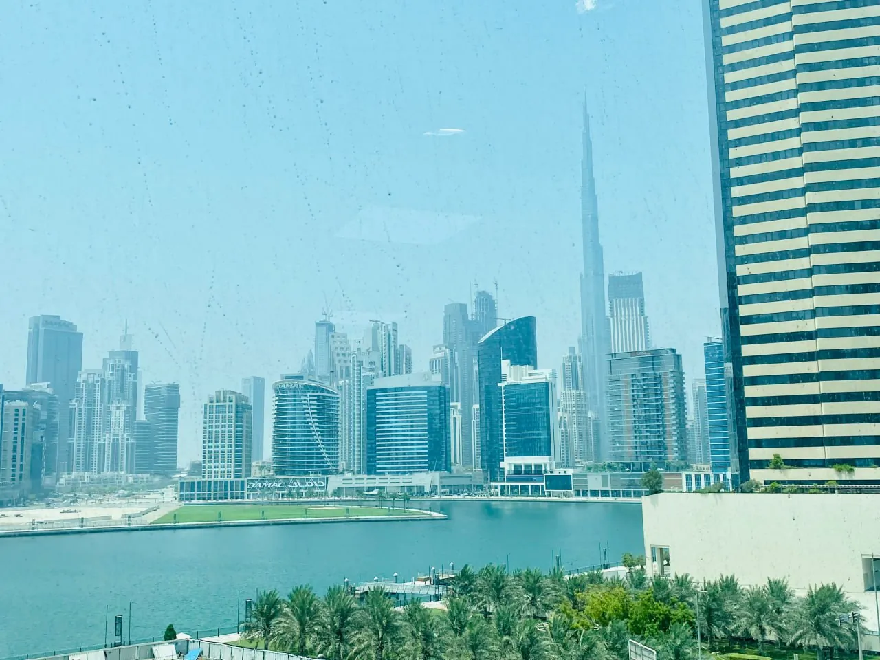 View from HBS Dubai office at U-Bora Tower Business Bay — Business Bay canal and Burj Khalifa skyline